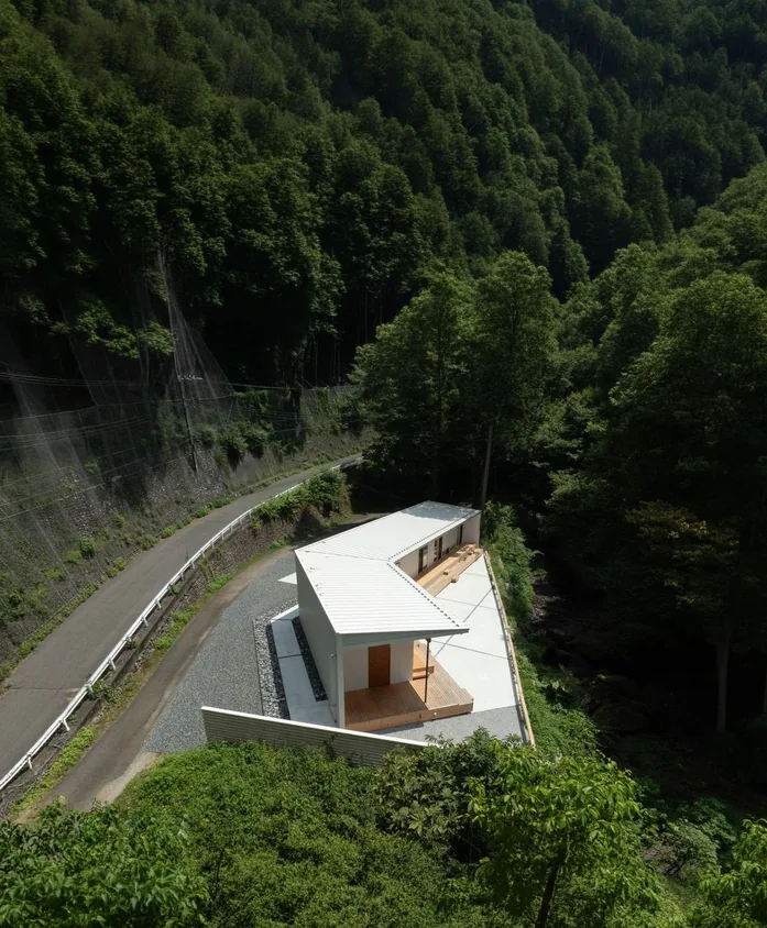 山道沿いに建つ HOUSE IN UNAZAWA を上空から望む