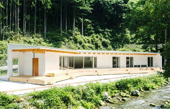 深い森を背に建つ平屋の外観